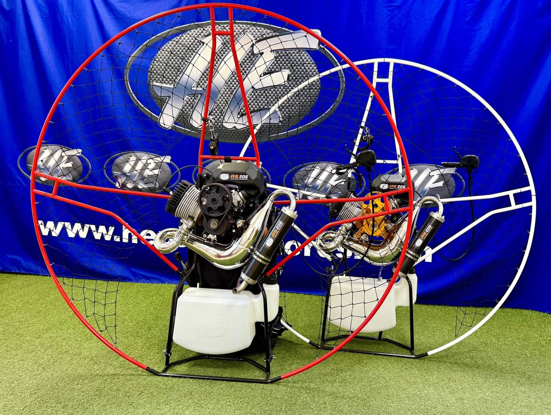 Daytona Sport Titanium RS 206cc complete paramotors with red and white cages, polished tuned exhausts and HE-branded fuel tanks