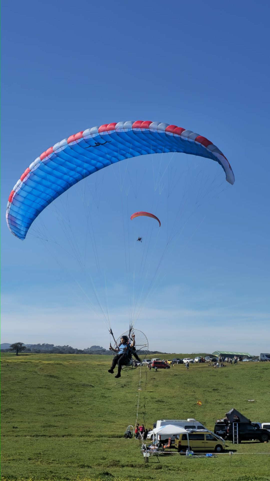 HE paramotor launching under a blue and red wing